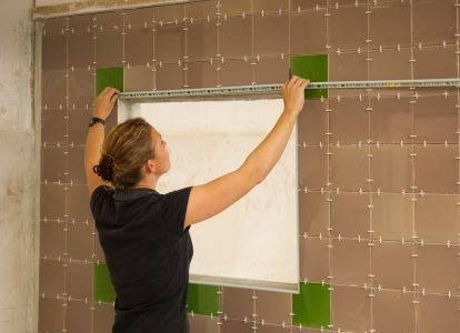 Woman tiling a wall in the Able Skills training centre