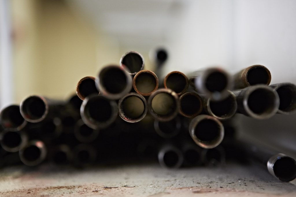 Featured image for article 'Find useful advice on making more environmentally-friendly decisions when it comes to picking your plumbing materials' shows a collection of metal pipes end view