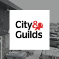 The City & Guilds logo in a white square over a black and white photo of the Able Skills construction training centre