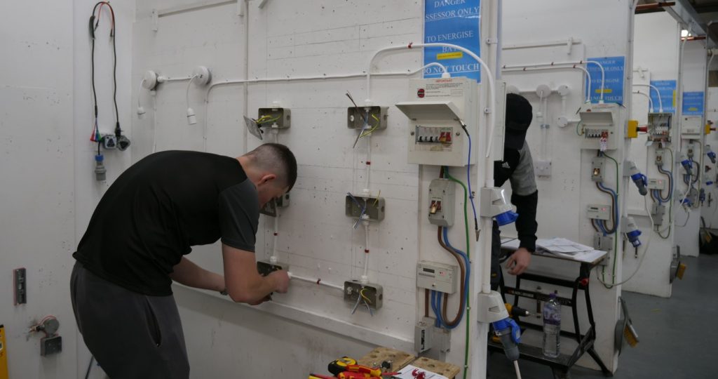 Person working on a series of sockets in the Able Skills electrical training workshop bays