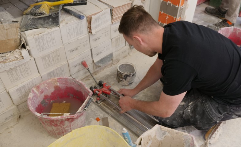 Person cutting tiles at the Able Skills Construction Training Centre