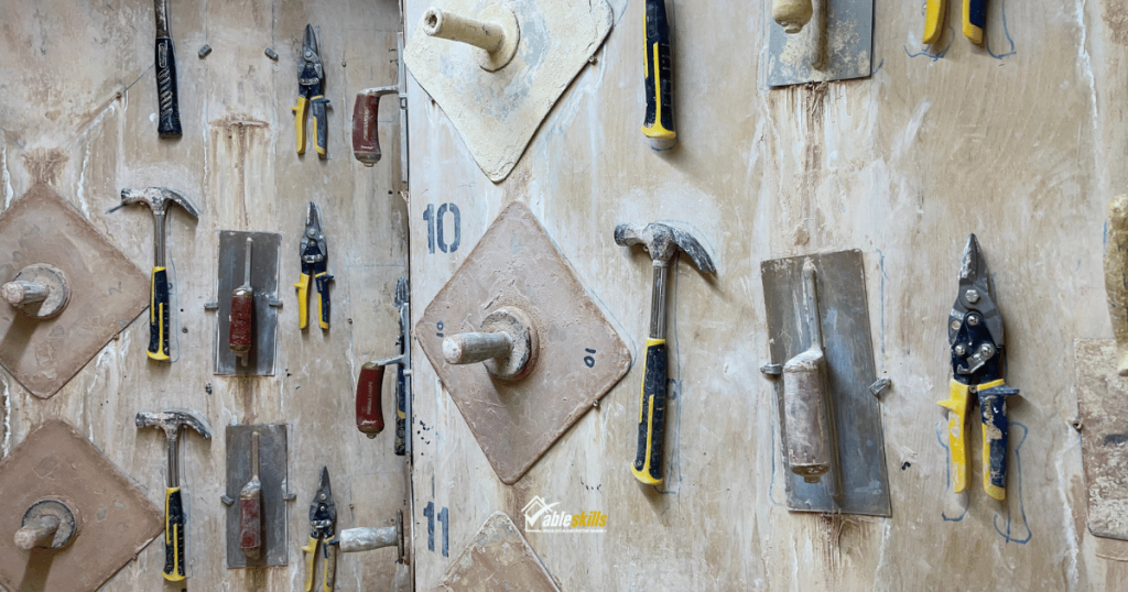 a selection of tools, including hammers and trowels, fixed to the wall