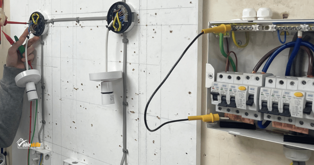 Lighting circuits and a fuse box mounted on a wall, a pair of hands are working on the wiring
