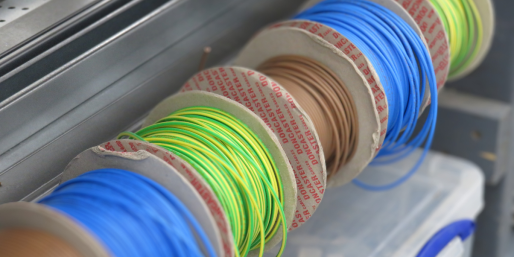 Rolls of electrical wire in blue, green and yellow and brown