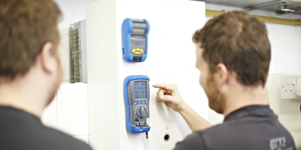 Two gas engineers using a gas testing device