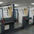 Image shows a row of plumbing workshop bays with tools, toilets, baths and basins, indicating a training facility where students will learn to install bathrooms.